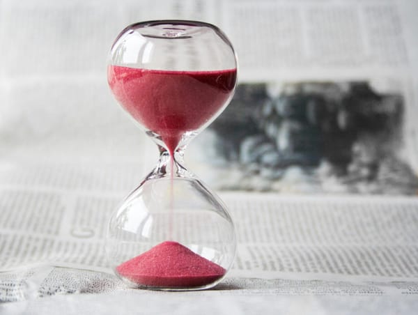 An hourglass on a newspaper